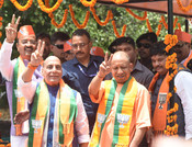 LUCKNOW, APR 29 (UNI):- Defence Minister and BJP candidate for Lucknow Parliamentary seat Rajnath Singh with Uttar Pradesh Chief Minister Yogi Adityanath flashes victory sign on  way to file nomination for the Lok Sabha Election -2024, in Lucknow on Monday.UNI PHOTO-27u